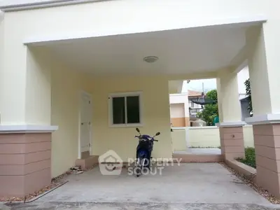 Covered parking area with a motorcycle in a modern residential property.