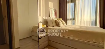 Cozy sunlit bedroom with modern decor and large windows.