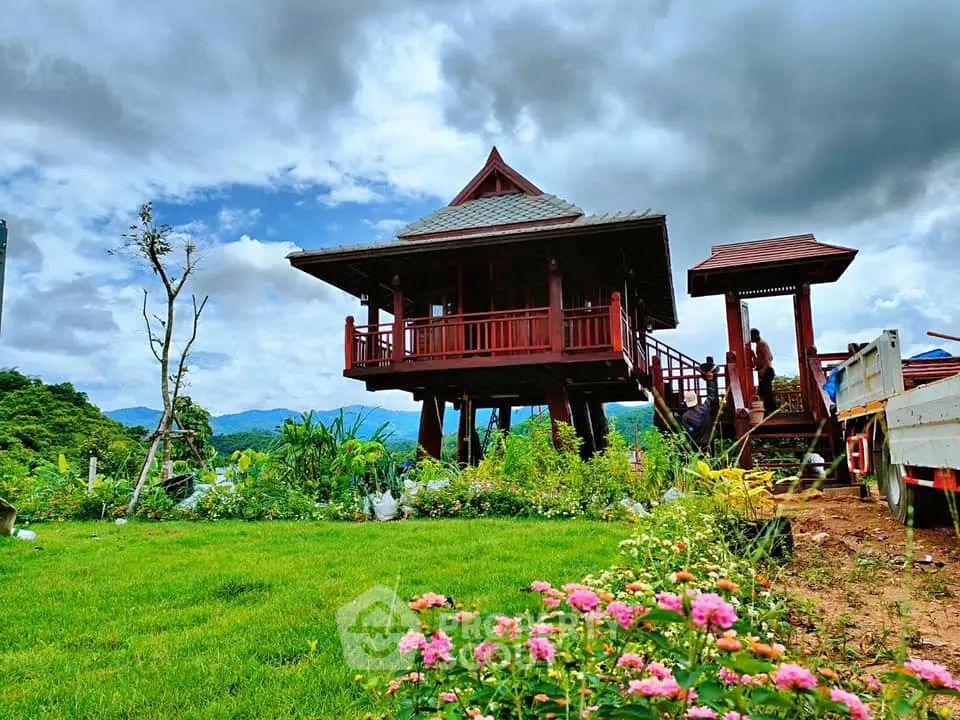 Charming elevated wooden house with lush garden and scenic mountain views, perfect for serene living.
