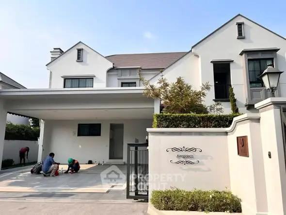 Elegant modern house with spacious driveway and manicured garden in a serene neighborhood.