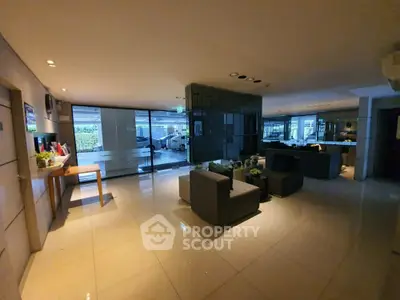 Spacious modern living room with sleek furniture and large windows offering natural light.