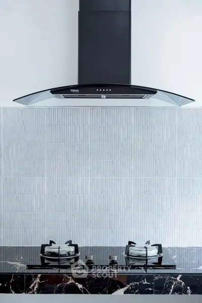 Modern kitchen with sleek gas stove and stylish range hood, perfect for culinary enthusiasts.