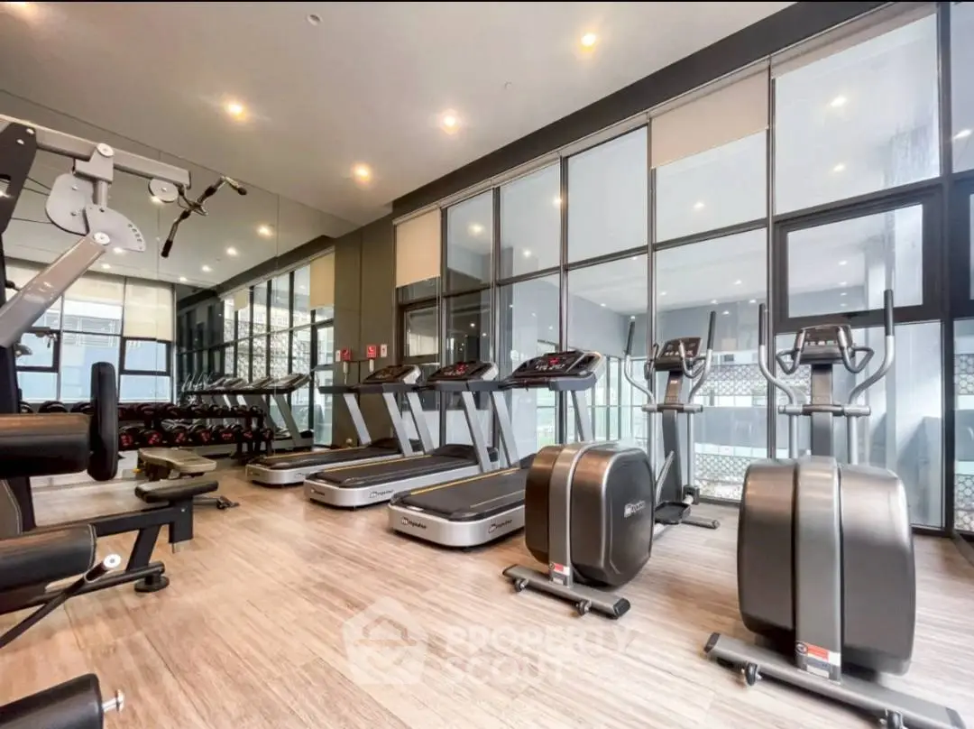 Modern gym with state-of-the-art fitness equipment and large mirrors.