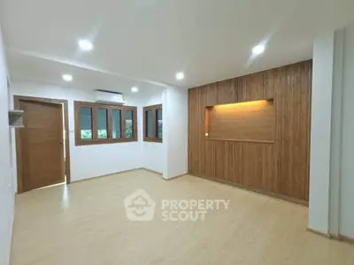 Spacious modern living room with wooden accents and recessed lighting