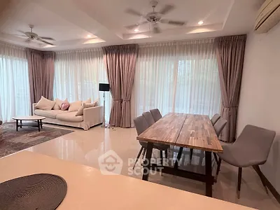 Spacious living room with elegant dining area and large windows for natural light.