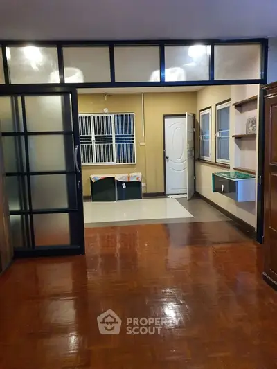 Spacious interior with wooden flooring and sliding glass doors, ideal for modern living.