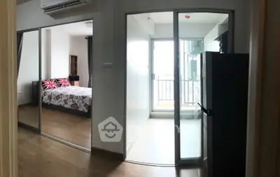 Modern apartment interior with bedroom and balcony view, featuring sleek design and natural light.