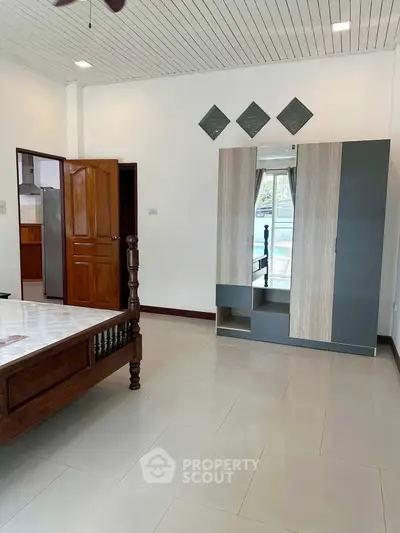 Spacious bedroom with modern wardrobe and wooden bed frame