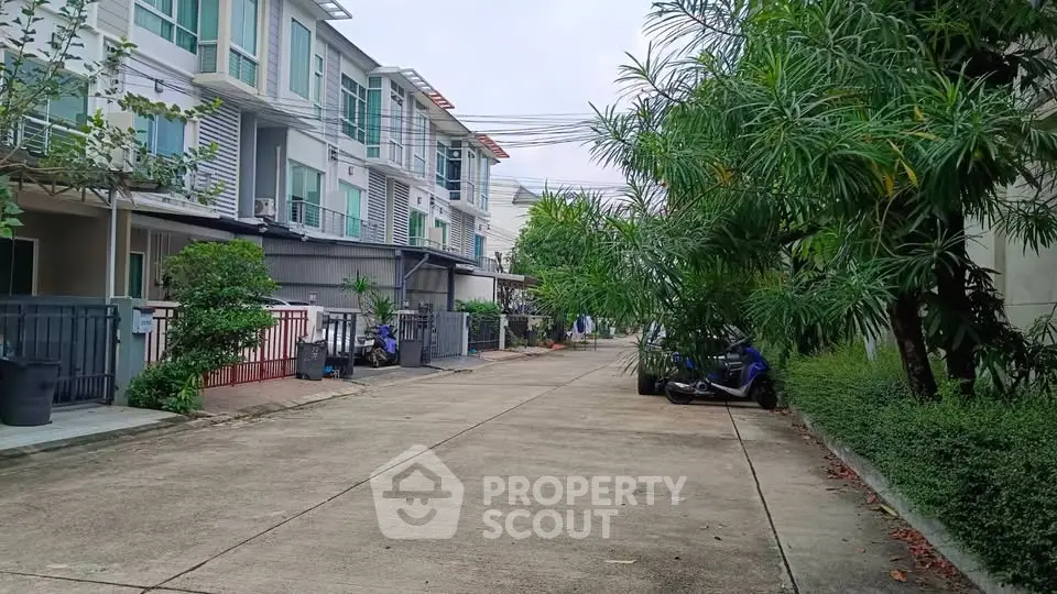 Modern townhouse complex with lush greenery and spacious driveway