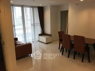 Spacious modern living room with dining area and large windows in a city apartment.