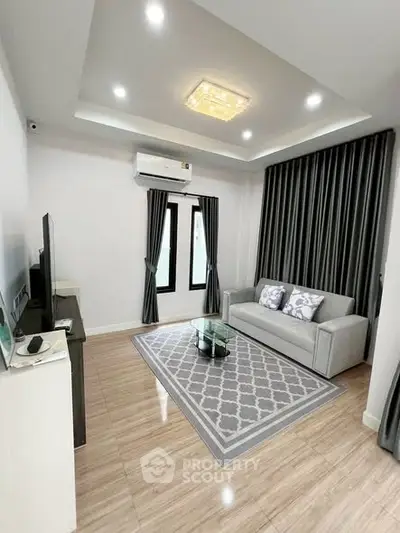 Modern living room with elegant decor, featuring a cozy sofa, stylish rug, and ambient lighting.