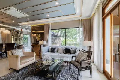 Luxurious living room with elegant decor and large windows offering a serene garden view.
