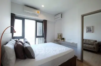 Modern bedroom with large windows and adjacent cozy living area