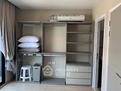 Modern bedroom with open closet and air conditioning unit, showcasing sleek storage solutions.