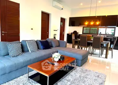 Modern living room with stylish furniture and open kitchen layout, perfect for contemporary living.