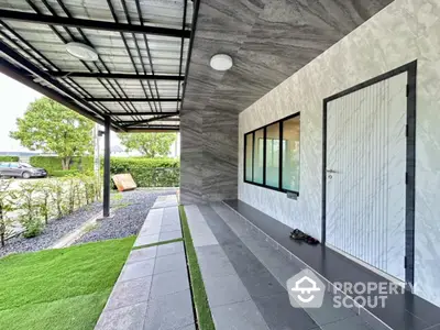 Modern house entrance with sleek design and lush greenery