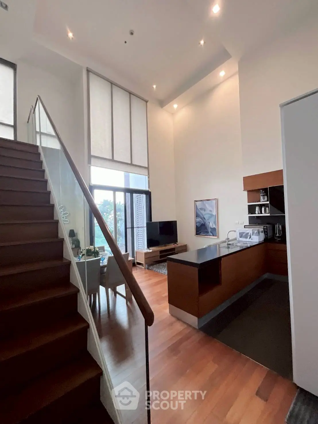Modern duplex living room with high ceilings and stylish kitchen