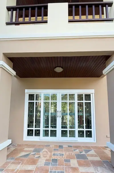 Charming balcony with elegant tile flooring and stylish wooden ceiling accents.