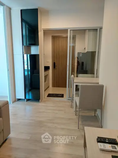 Modern apartment interior with sleek design and open layout, featuring a compact dining area and stylish entrance.