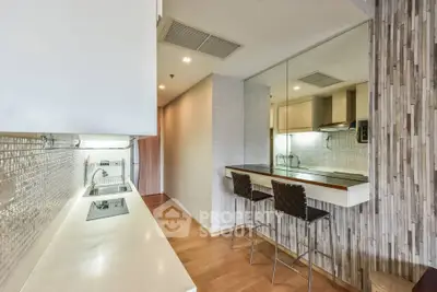 Modern kitchen with sleek design and open layout, featuring a breakfast bar and stylish backsplash.