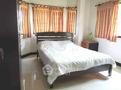 Cozy bedroom with natural light and stylish curtains, perfect for relaxation.