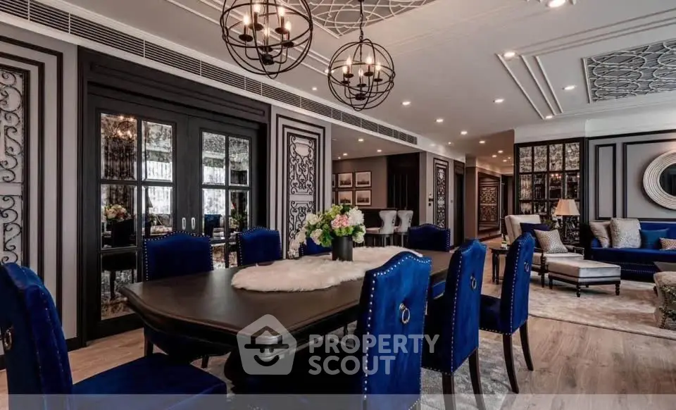 Luxurious dining and living room with elegant decor and plush blue chairs