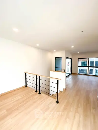 Spacious modern living area with large windows and wooden flooring