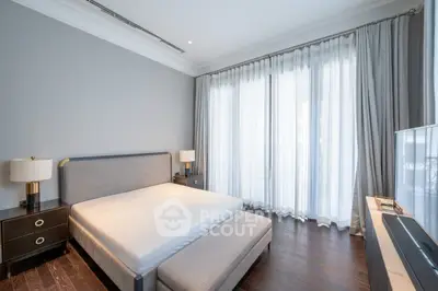 Elegant bedroom with modern decor and large windows offering natural light