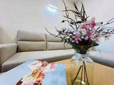Elegant living room with cozy beige sofa and floral decor, perfect for relaxation.