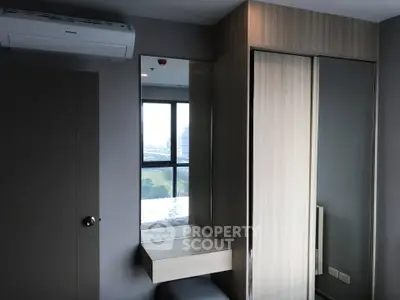 Modern bedroom with built-in wardrobe and air conditioning unit, featuring a sleek design and ample natural light.