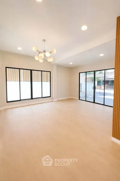 Spacious modern living room with large windows and elegant lighting