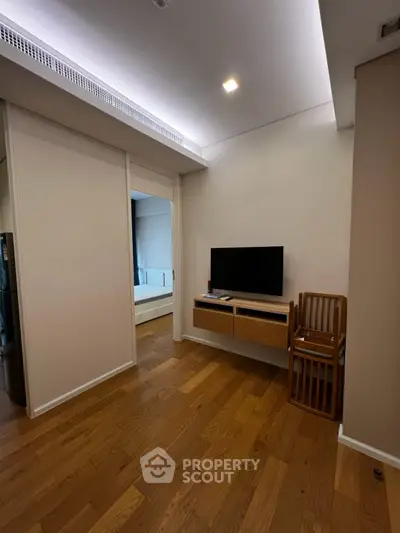Modern living room with wooden flooring and sleek TV setup