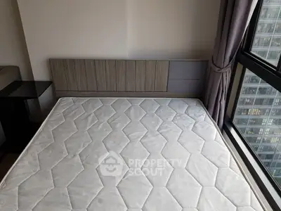 Modern bedroom with large window and city view, featuring a minimalist bed frame and mattress.