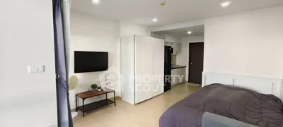Modern studio apartment with open layout, featuring a cozy bed, sleek kitchen, and stylish living area.