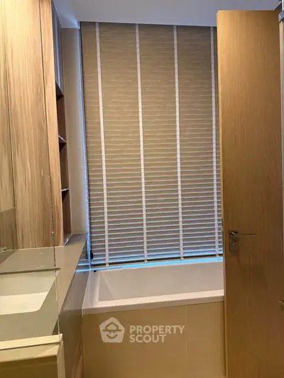 Modern bathroom with wooden accents and bathtub, featuring sleek blinds for privacy.