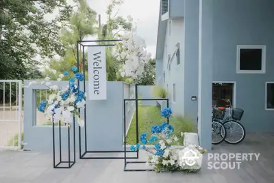 Modern building entrance with welcome sign and floral decorations