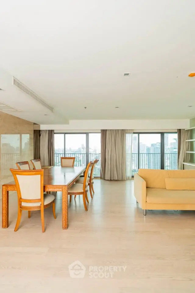 Spacious living room with elegant dining area and city view balcony