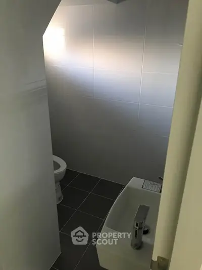 Compact bathroom with modern fixtures and tiled walls