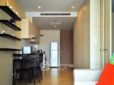 Modern apartment interior with compact kitchen and cozy living area, featuring sleek wooden finishes and contemporary decor.