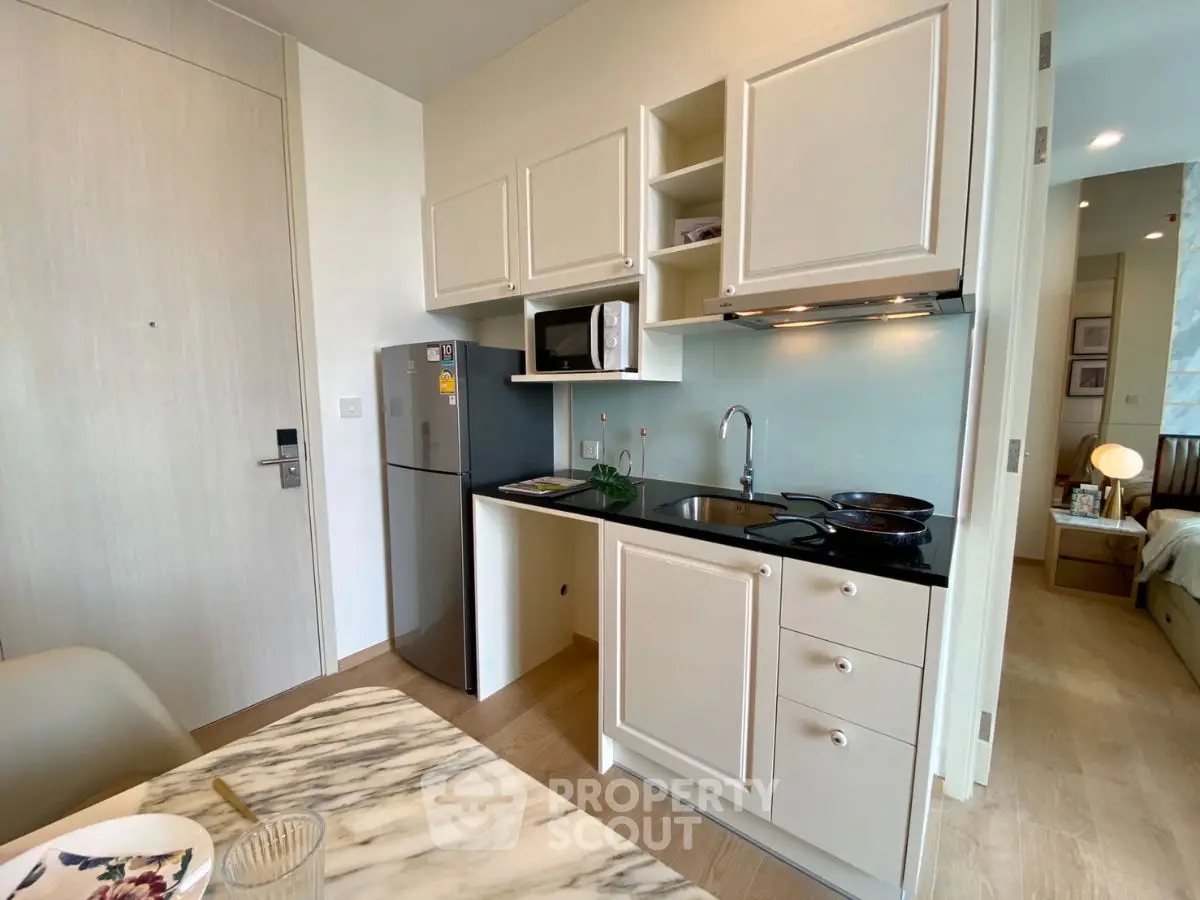 Modern compact kitchen with sleek cabinetry and dining area in stylish apartment