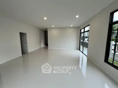 Spacious modern living room with large windows and glossy tiled flooring