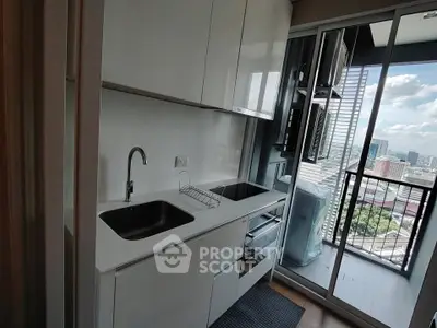 Modern kitchen with sleek cabinetry and balcony view in urban apartment