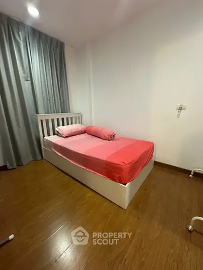 Cozy bedroom with single bed and wooden flooring, perfect for a minimalist lifestyle.