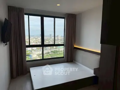 Modern bedroom with large window offering stunning city view