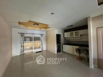 Spacious open-layout kitchen with modern cabinets and large windows for natural light.