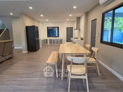 Spacious open-plan living and dining area with modern kitchen and stylish wooden furniture.