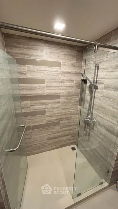 Modern bathroom with glass shower enclosure and stylish tile design.