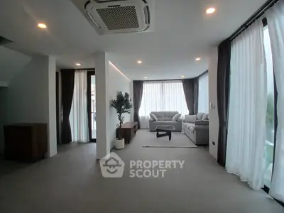 Spacious modern living room with large windows and elegant furnishings