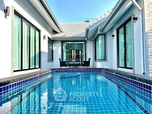 Modern home with sleek pool and stylish outdoor seating area.