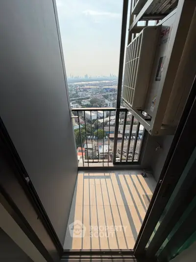 Compact balcony with city view and air conditioning unit, perfect for urban living.
